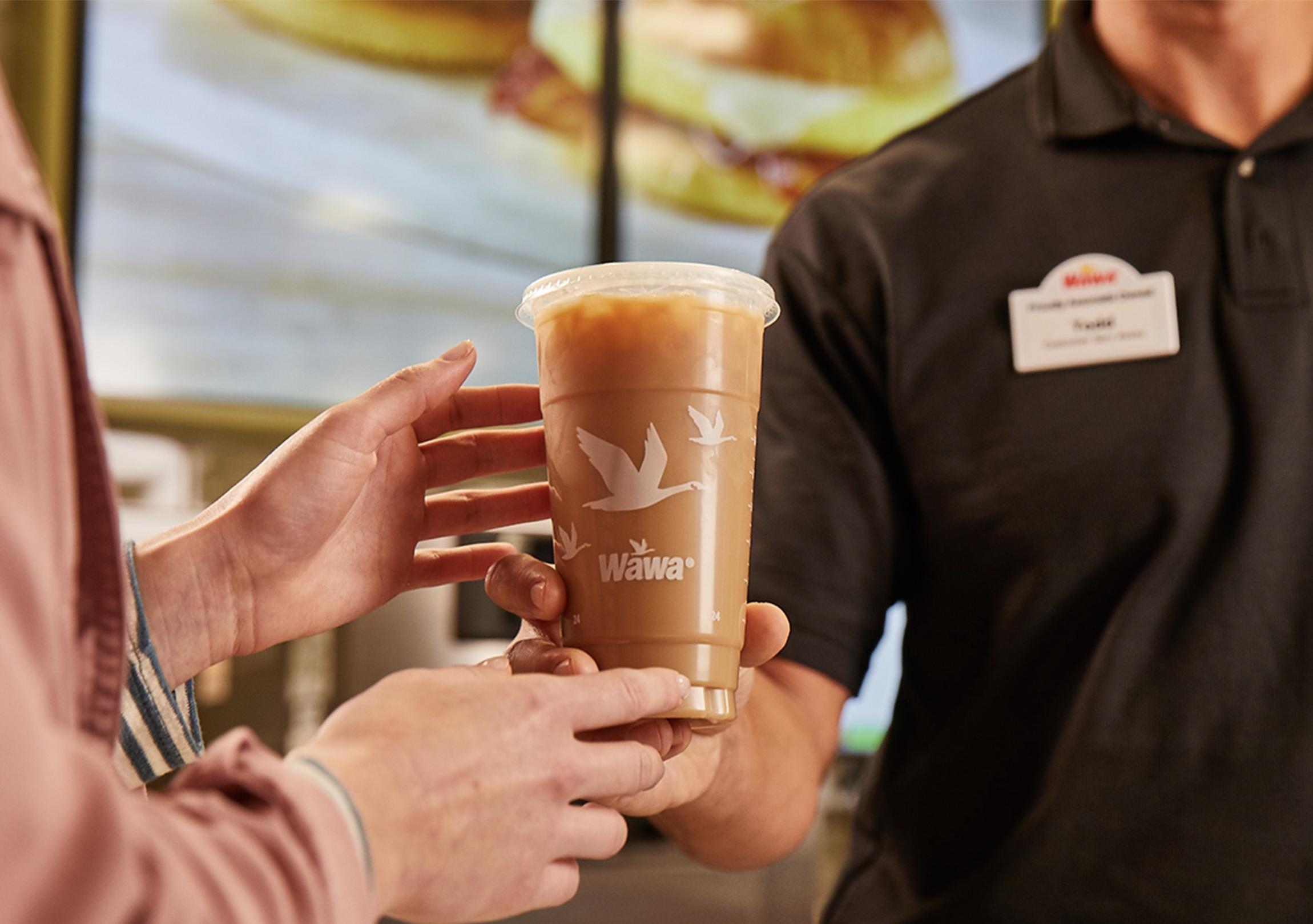 A customer holding a Wawa branded cup