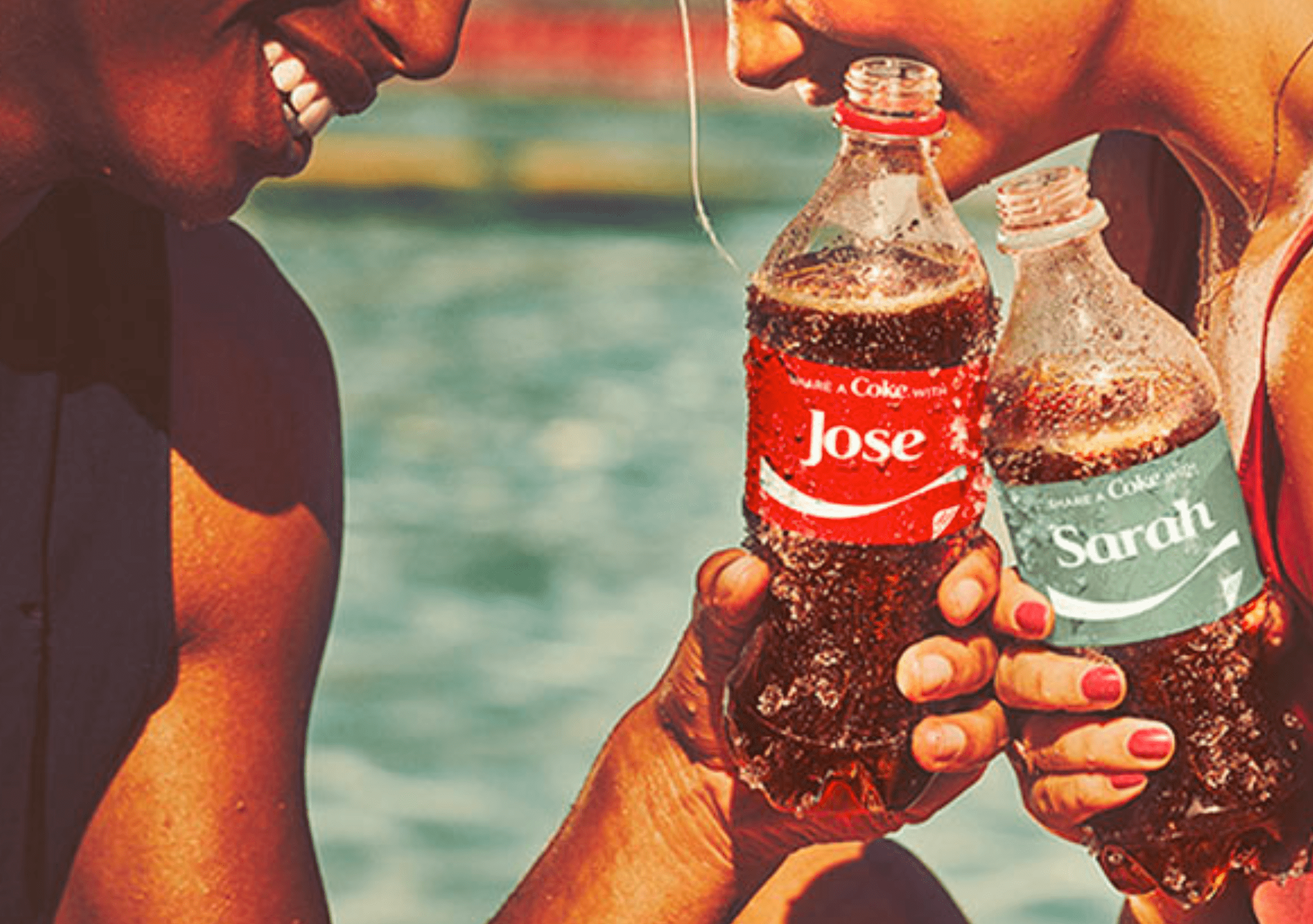 two woman holding custom coke bottles and cheers-ing