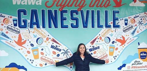 Woman in front of wawa gainesville mural